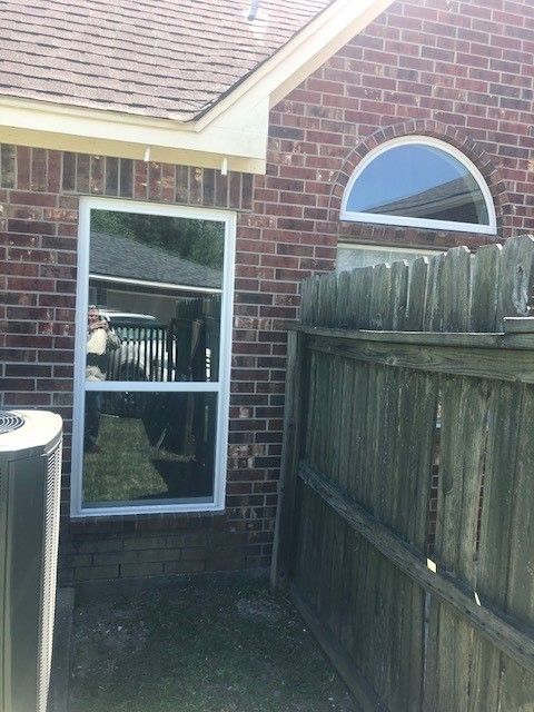 A brick house with a wooden fence and a window