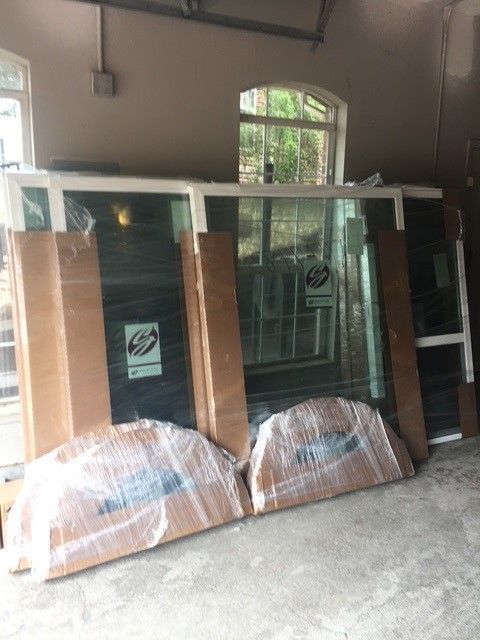 A bunch of windows wrapped in plastic are sitting in a room