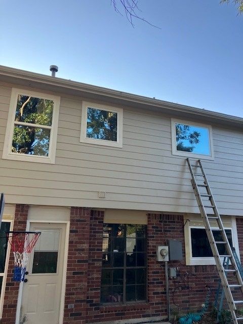 A ladder is sitting on the side of a brick house.