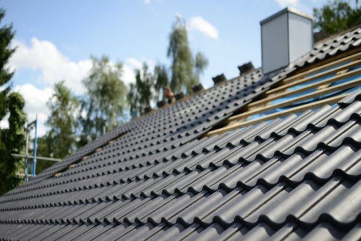 A roof is being built with a chimney in the background.