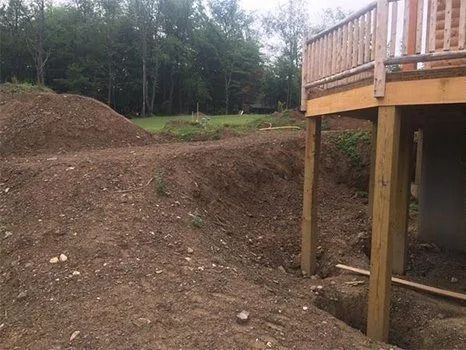 Pile of dirt and a wooden deck under construction outdoors.