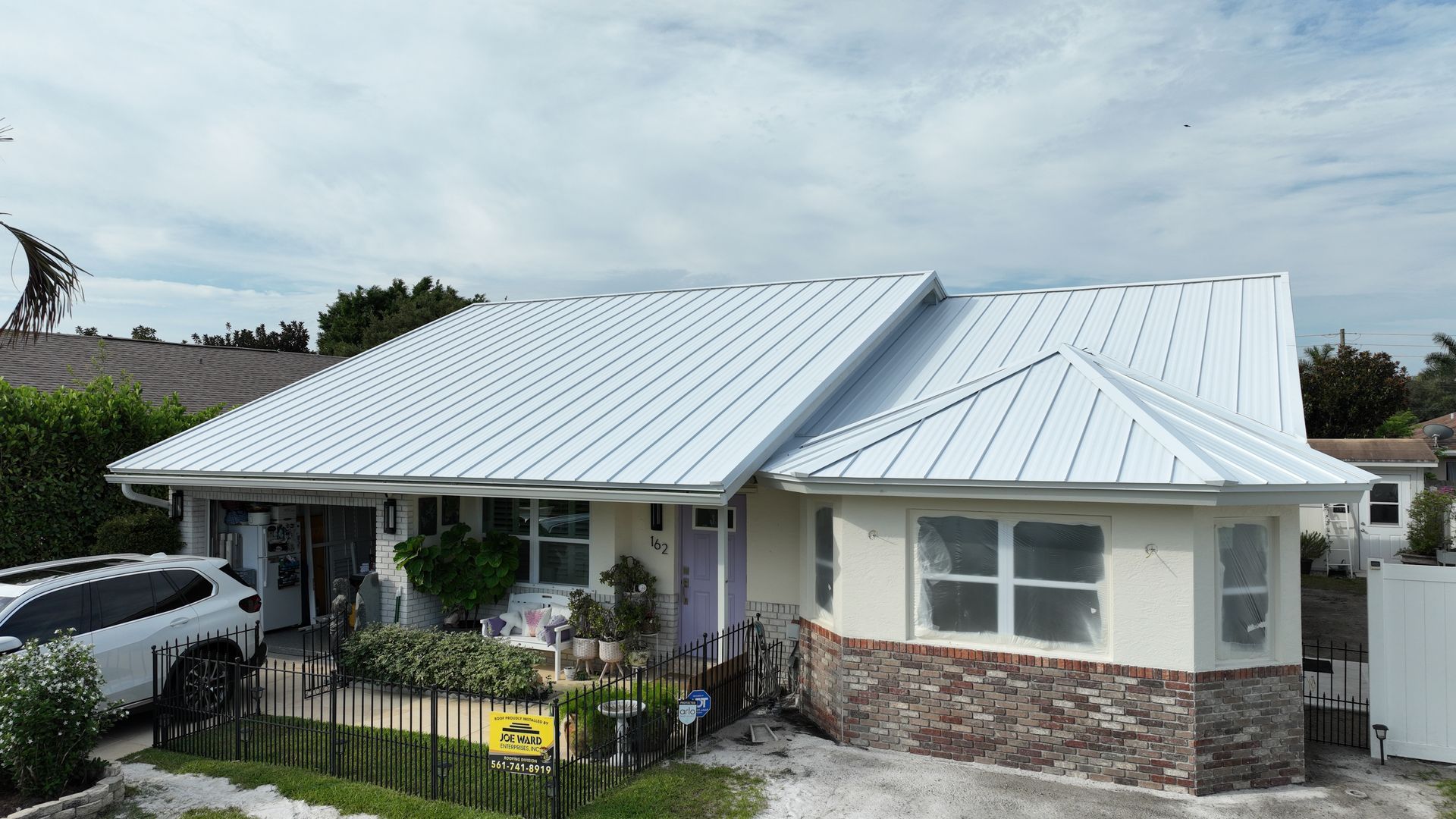 Indian Creek Jupiter home Bone White 24‑gauge striated metal roof, installed by Joe Ward Roofing