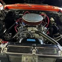 A close up of the engine of a car with the hood open.