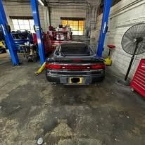 A car is sitting on a lift in a garage.