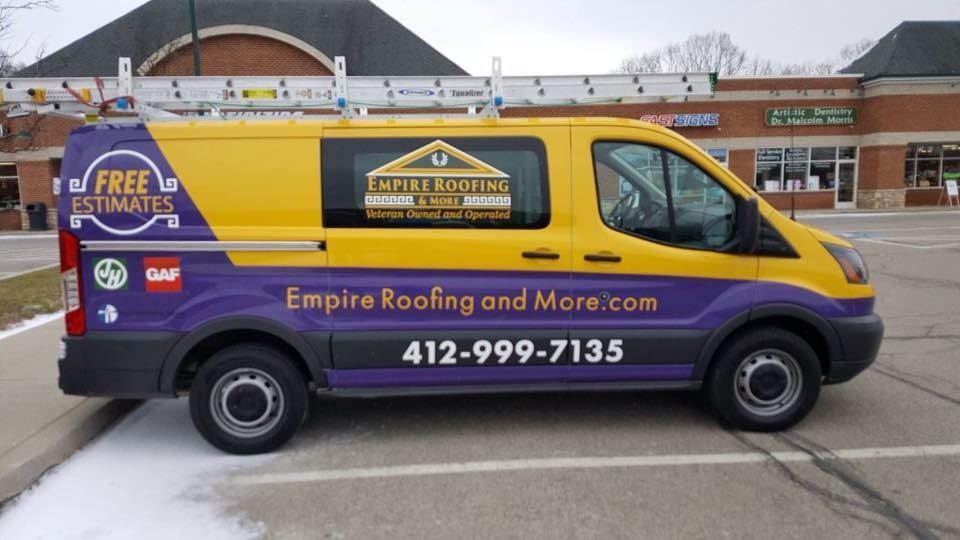 Yellow and purple Empire Roofing van with ladder parked in front of a shopping center.