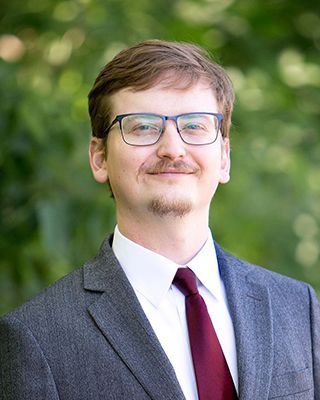 A man in a suit and tie is smiling for the camera.