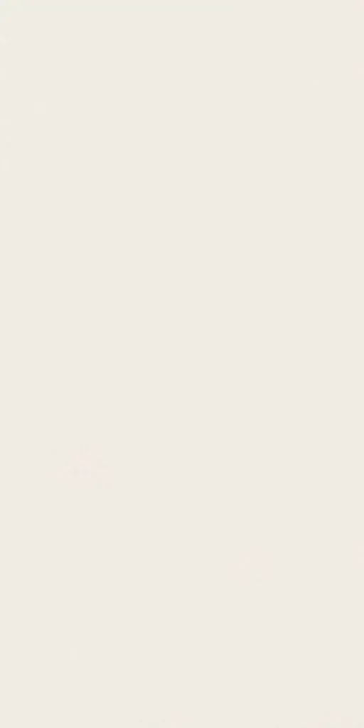 Nearly blank off-white wall with a tiny faint pink mark near the lower left