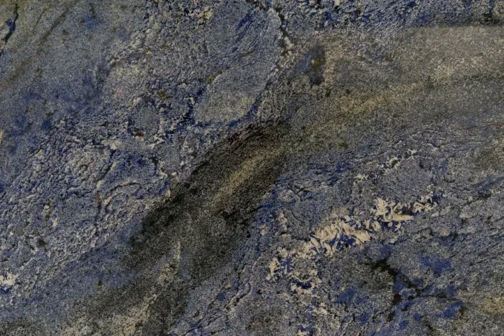 Close-up of rough gray-blue rock surface with dark cracks and mottled textures.