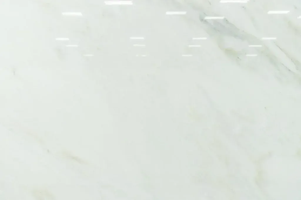 Light white marble surface with faint gray veining and subtle reflections