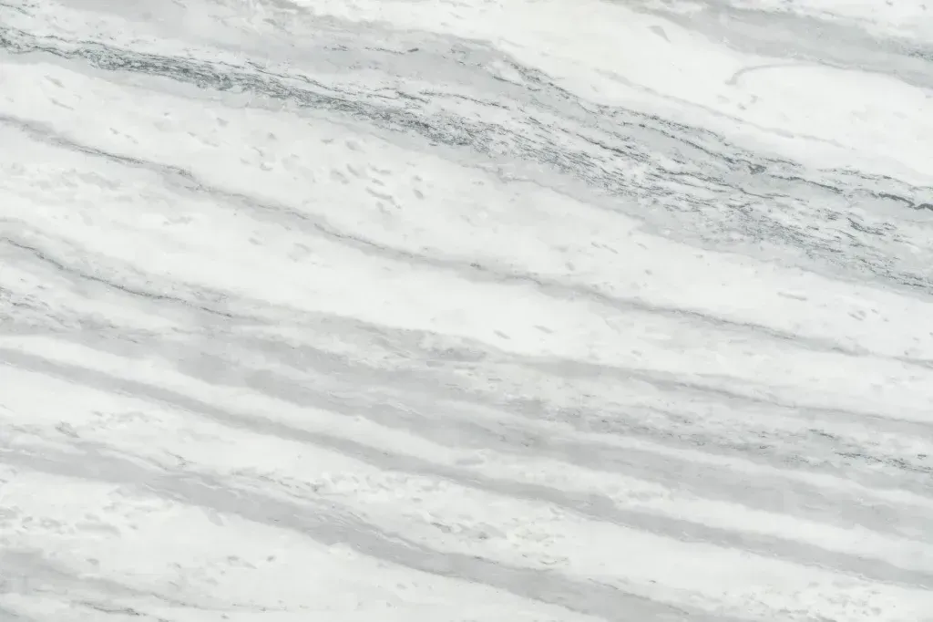 Snow-covered ground with gray streaks and scattered tracks or debris