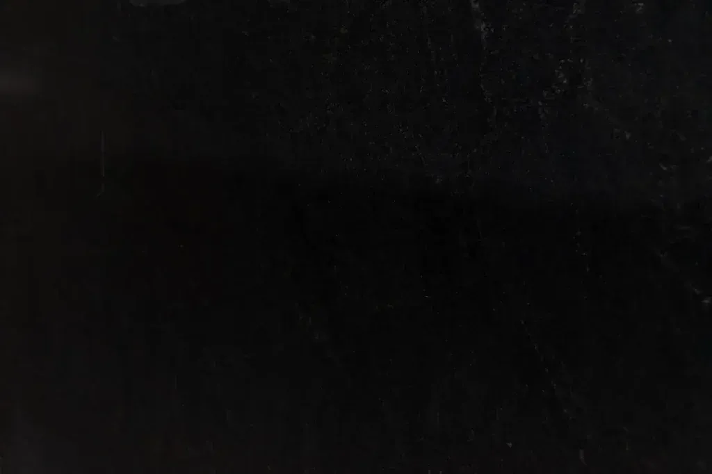 Nearly black, featureless surface with faint scratches and subtle texture