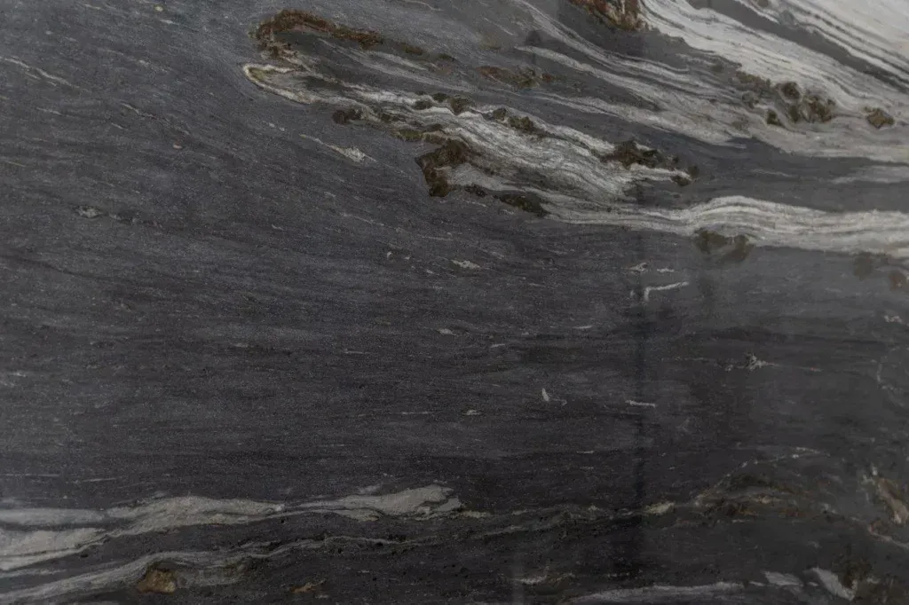Dark gray stone surface with light gray streaks and layered mineral patterns
