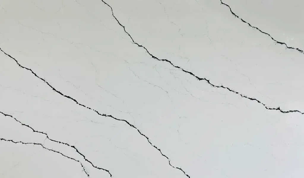 White marble-like surface with thin gray veining running diagonally across it