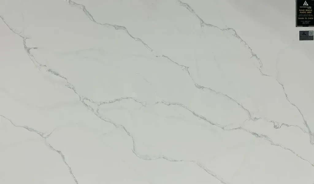 White marble surface with soft gray veining and a small label in the top-right corner