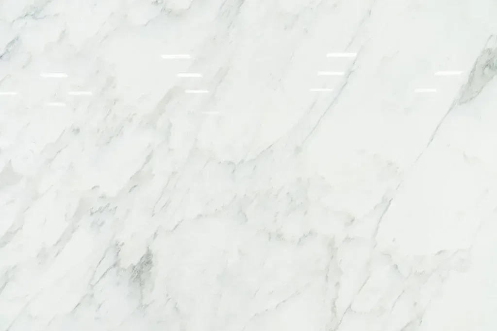 White marble surface with light gray veining and subtle diagonal streaks