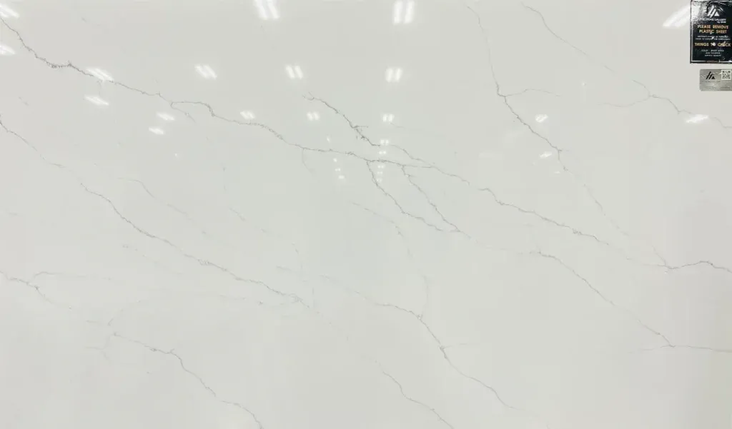White marble surface with faint gray veining and small glossy reflections