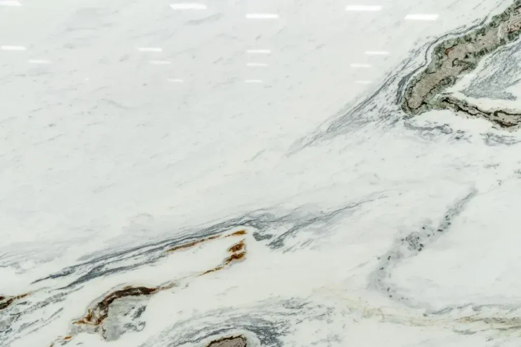 Abstract marbled white surface with gray and gold veining, like polished stone or snow