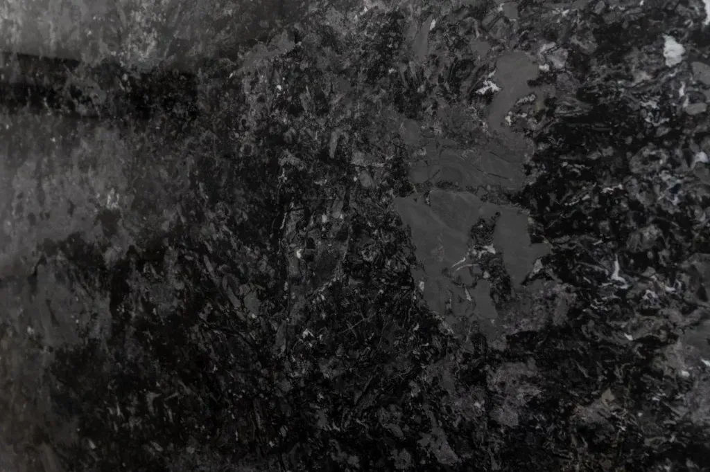 Dark, grainy abstract texture with black and gray speckled patterns