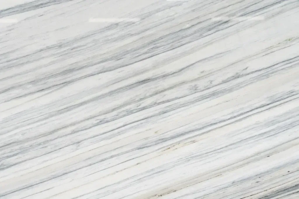 White marble-like surface with subtle gray veining and diagonal streaks