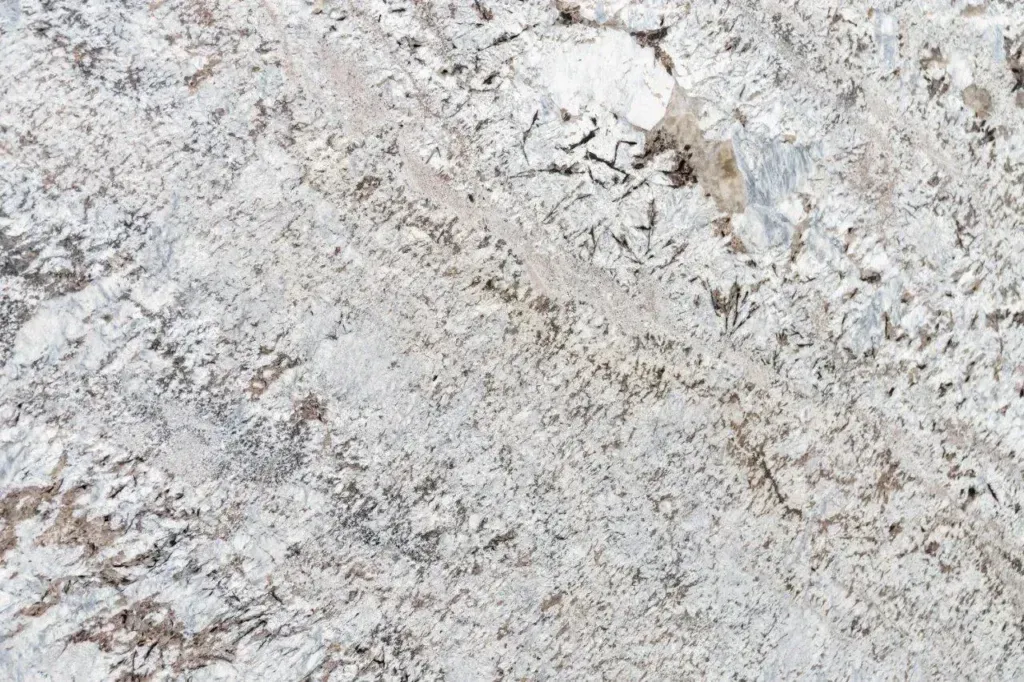 Close-up of a light gray and white speckled stone surface with diagonal veining.