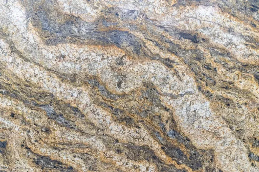 Close-up of layered gray, tan, and white rock with wavy mineral bands