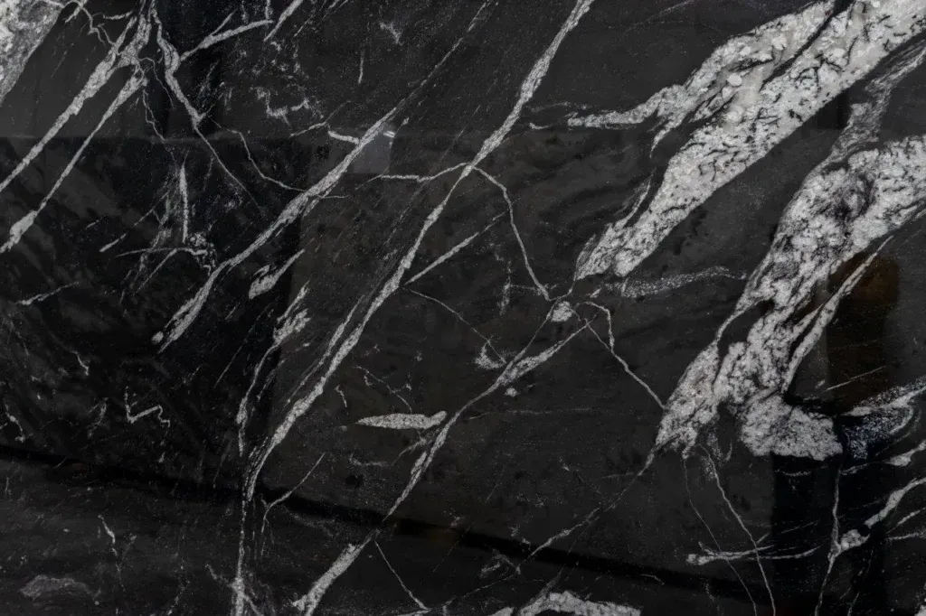 Black marble surface with white veining and a polished, textured pattern
