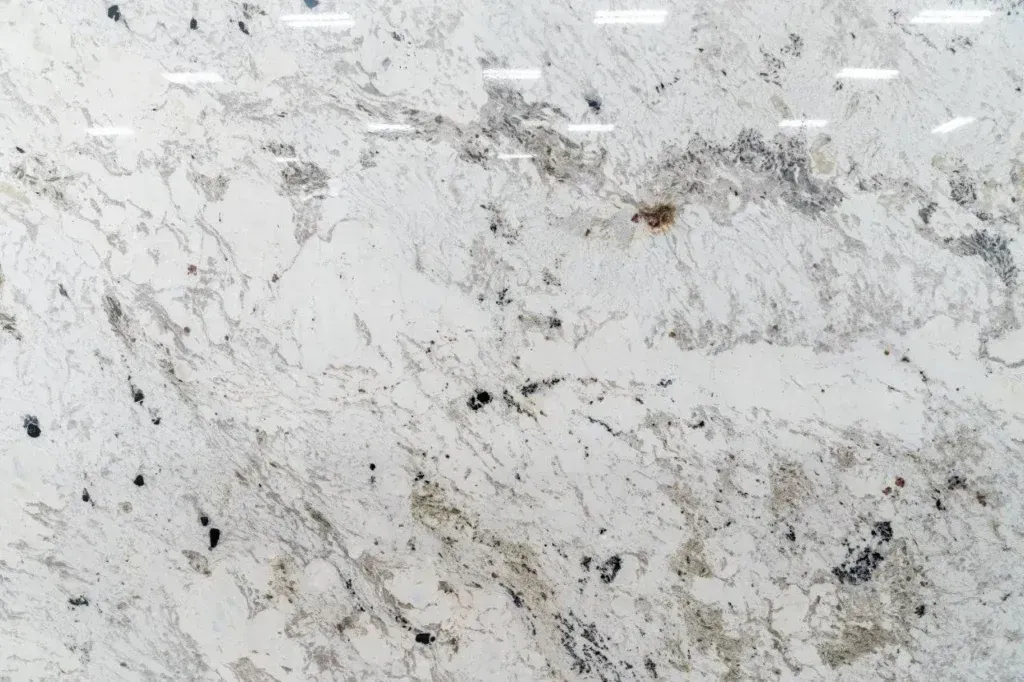 Light gray marble or granite surface with dark speckles and streaks