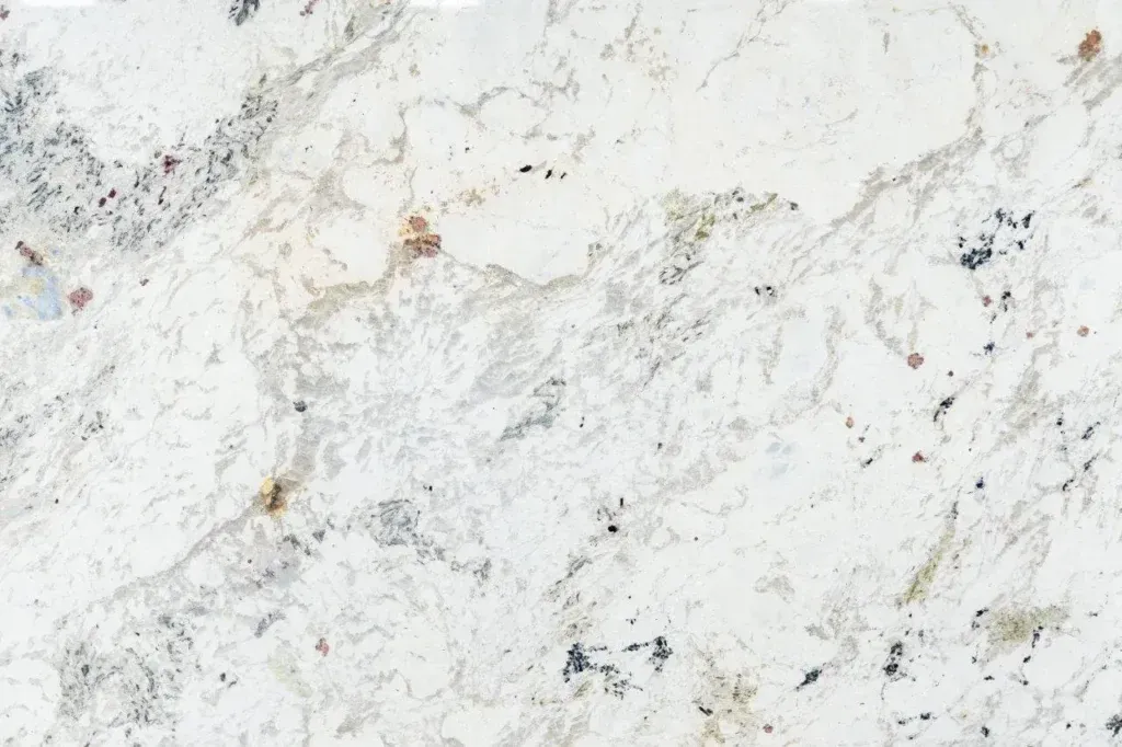 White marble surface with subtle gray veining and scattered beige speckles