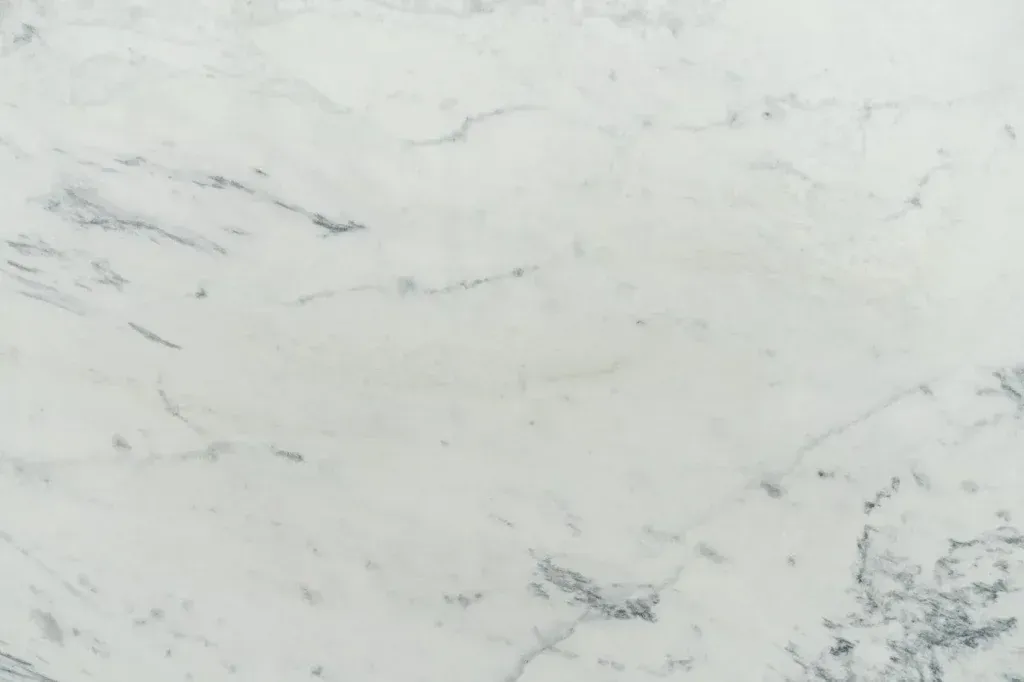 White marble surface with light gray veining and subtle darker streaks