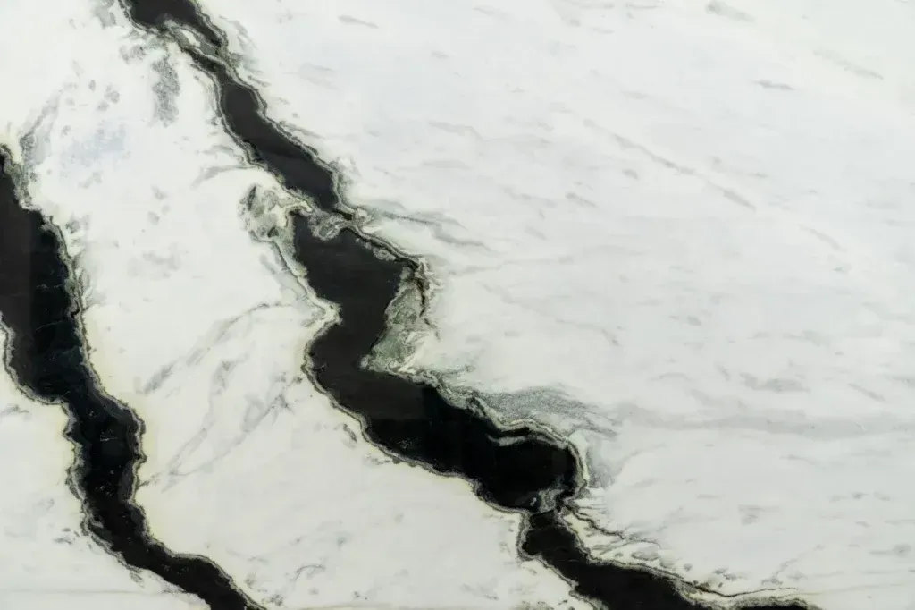 Aerial view of a dark, winding river cutting through snow-covered terrain