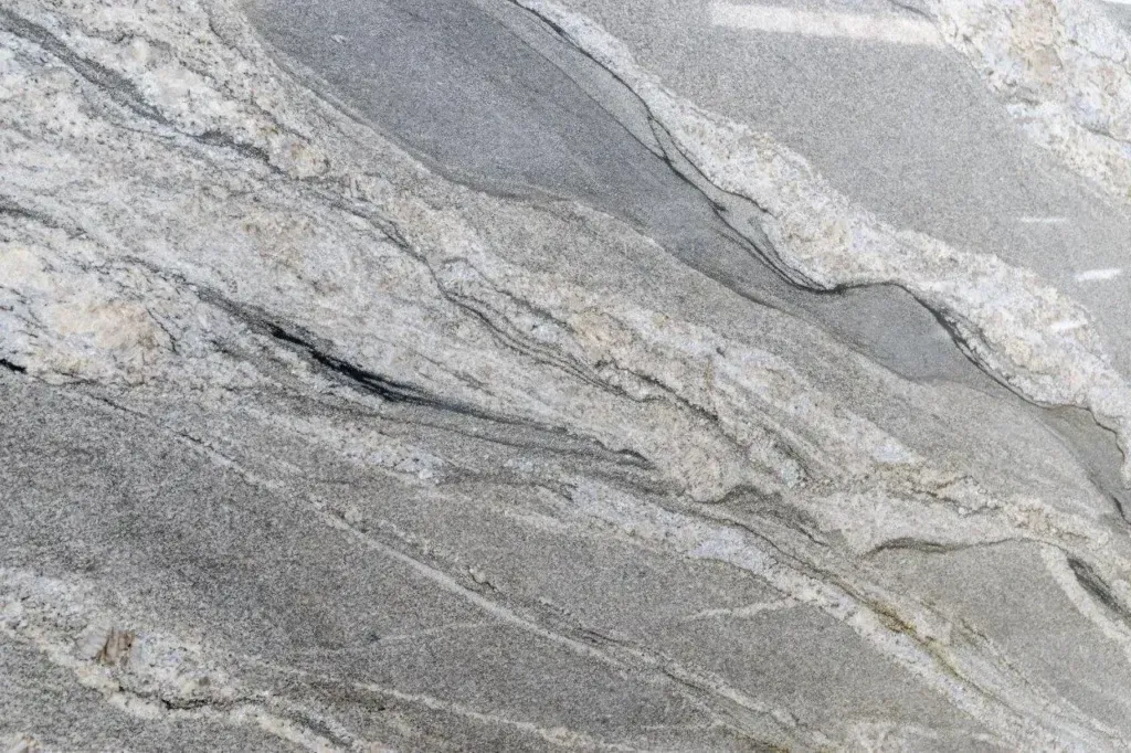 Close-up of gray and white stone with wavy, layered marble-like veins