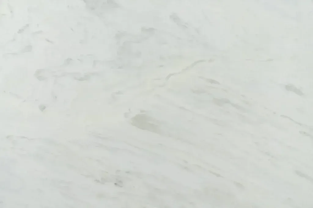 Close-up of a white marble-like surface with faint gray veins.