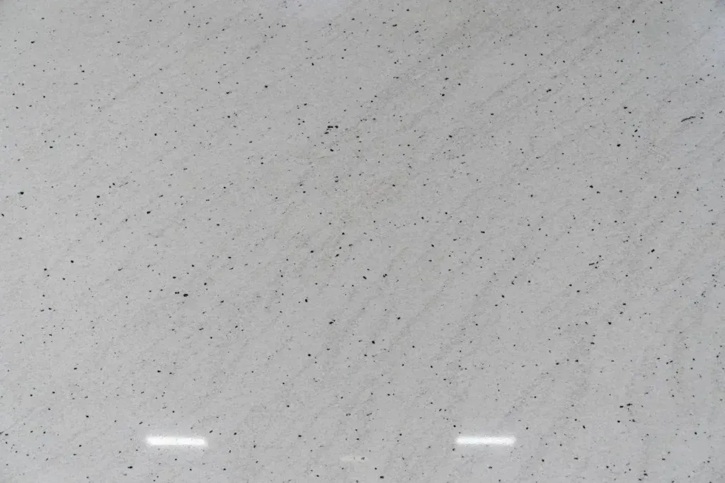 Light gray speckled surface with two small white rectangular reflections near the bottom