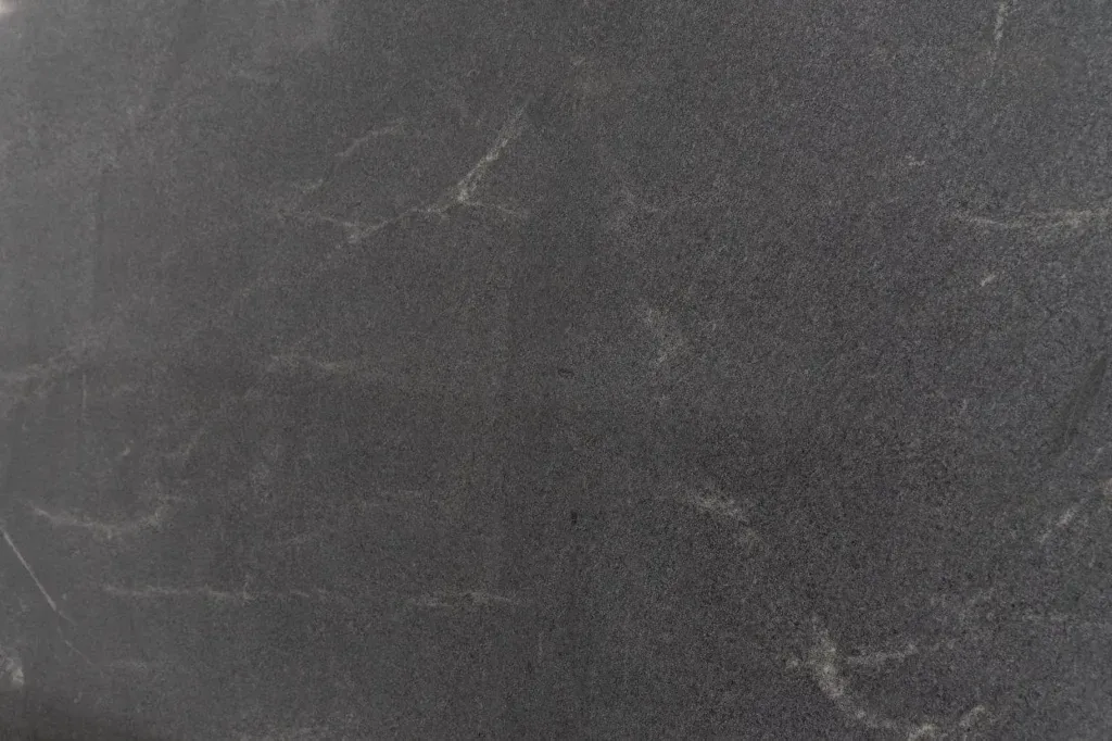 Dark gray, worn chalkboard with faint chalk smudges and scratches.