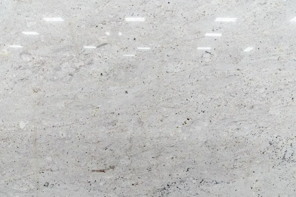Close-up of a light gray speckled surface with small dark flecks and subtle texture