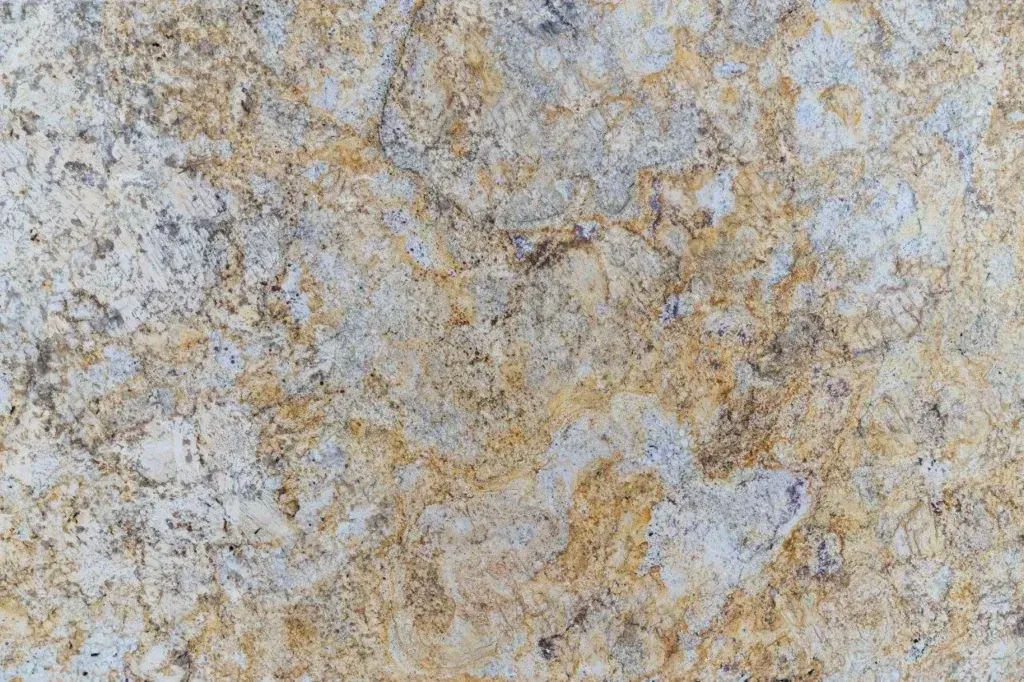 Close-up of a rough gray and tan stone surface with mottled texture and speckled patterns