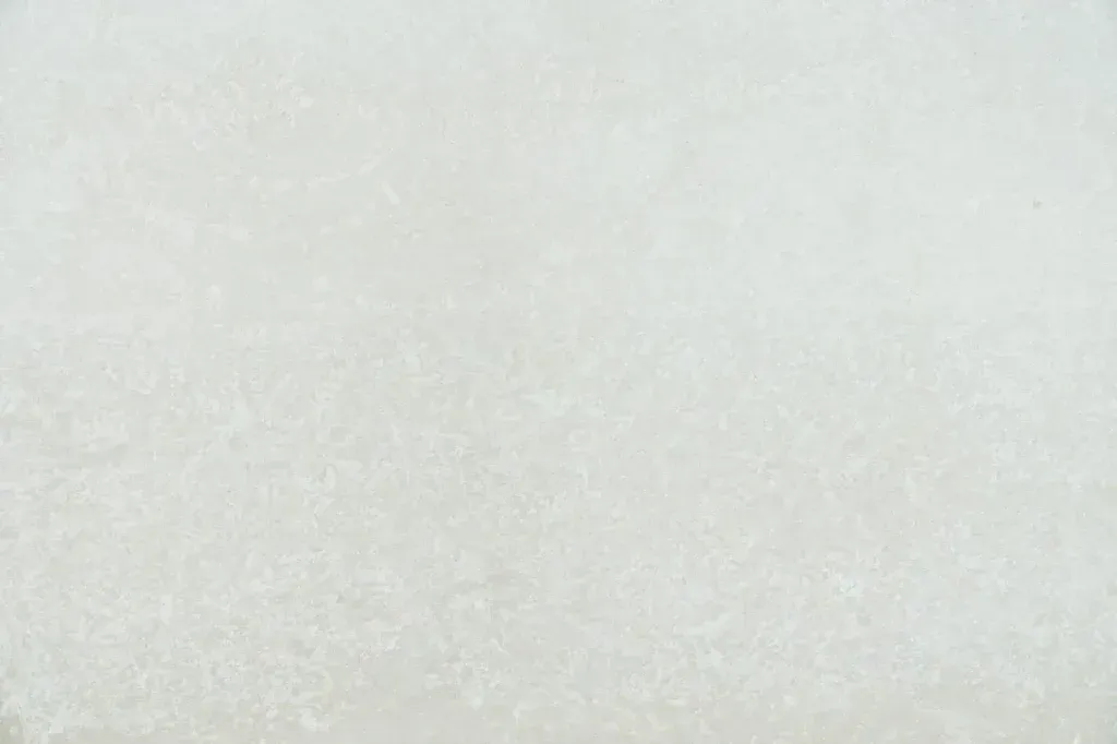 Light gray textured surface with a subtle gradient and faint vertical line near the left side