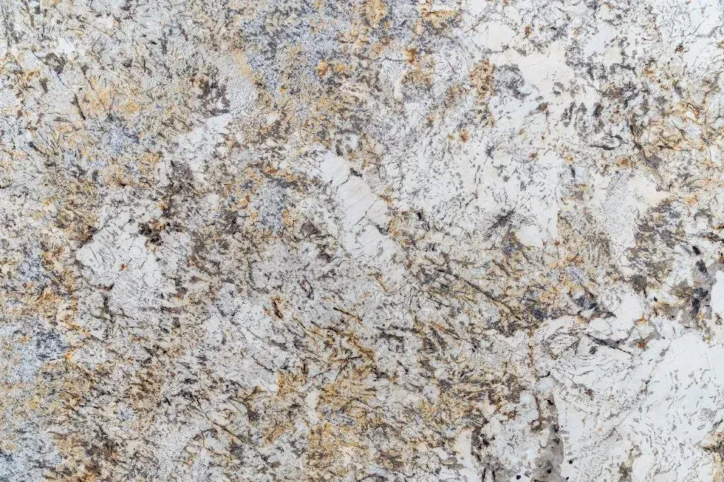 Close-up of a rough white and tan stone or concrete surface with speckled texture