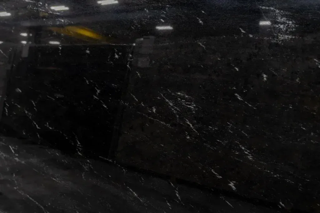 Dark, blurry scene with a black vehicle reflecting light and streaks across the frame.