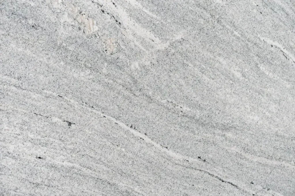 Light gray stone surface with subtle diagonal grain and fine dark specks