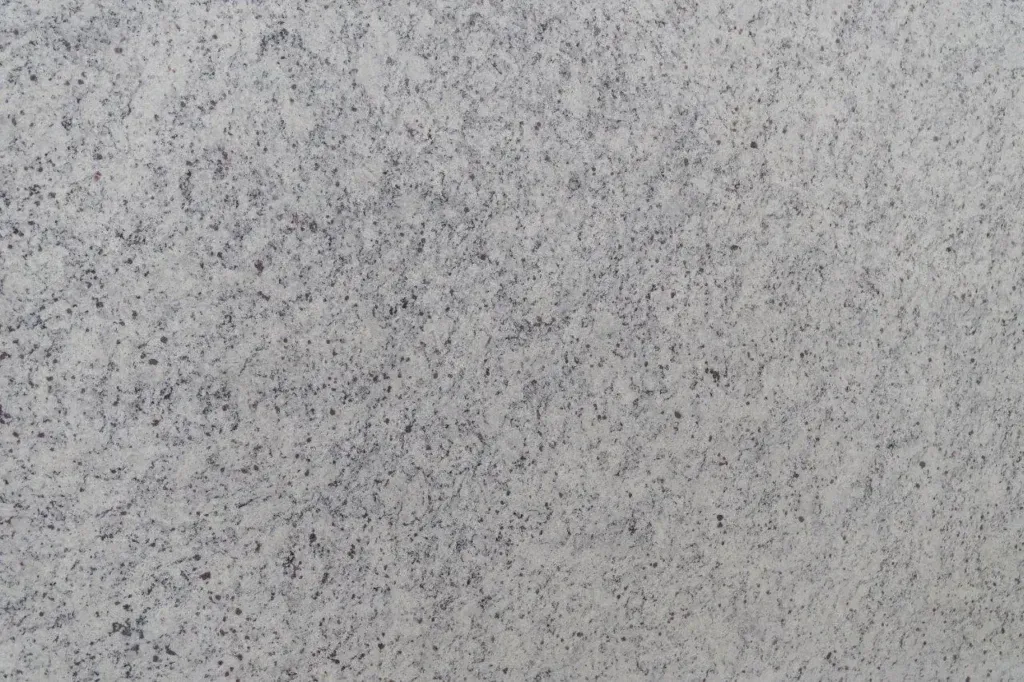 Gray speckled textured surface, resembling concrete or stone.