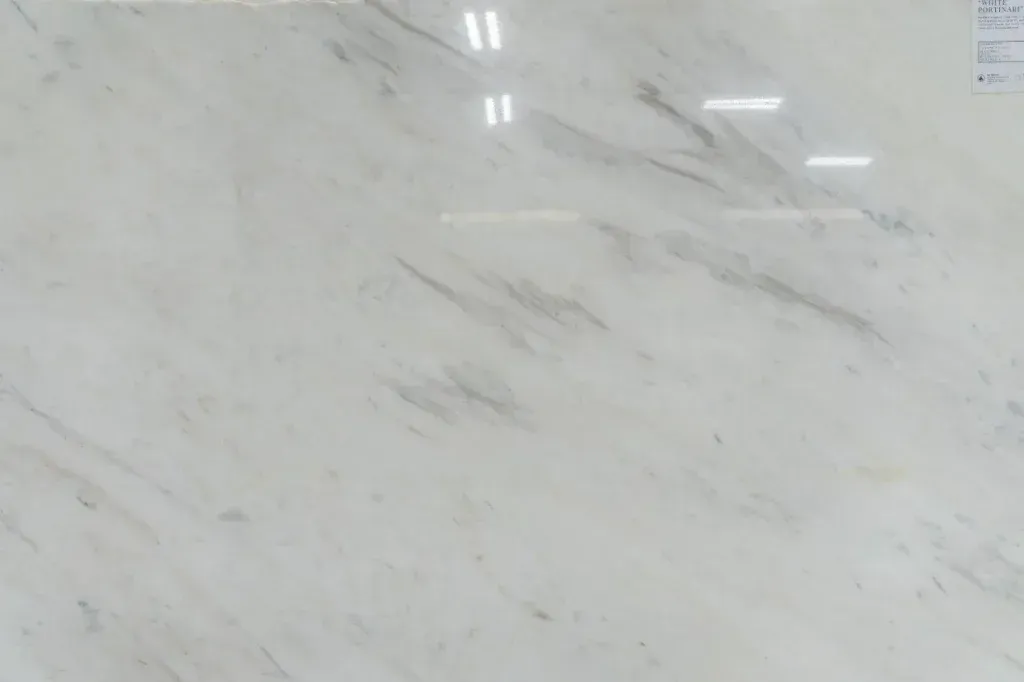 White marble surface with subtle gray veining and glossy reflections