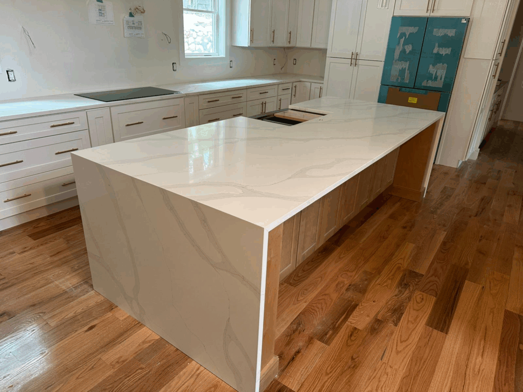 Modern kitchen with a large white marble island and wood flooring