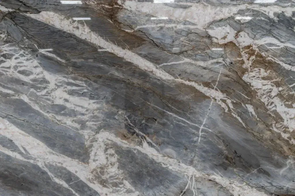 Gray and white marbled rock surface with diagonal veins and rough texture