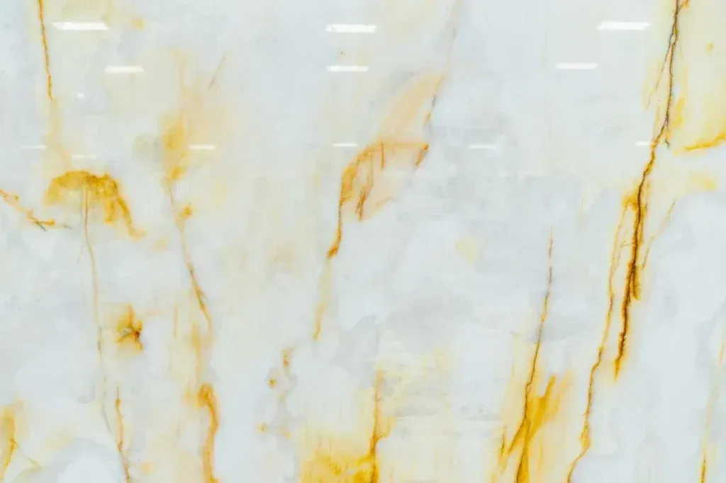 White marble-like stone with golden veining and soft gray streaks