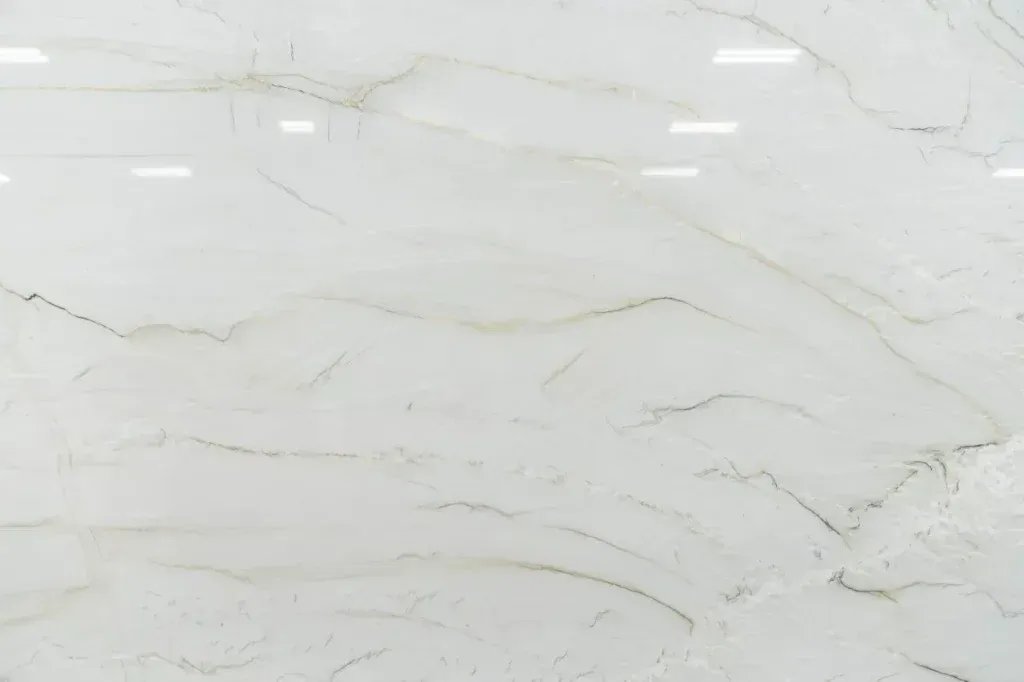 White marble-like stone surface with subtle gray veining and soft reflections