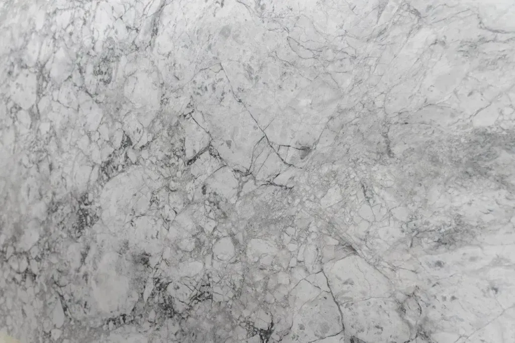 Gray marble-like stone surface with white veining and subtle dark cracks