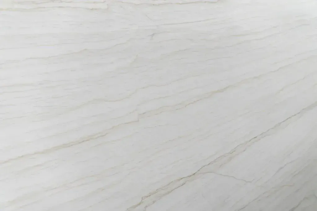 White marble surface with subtle gray veins and a smooth, glossy finish