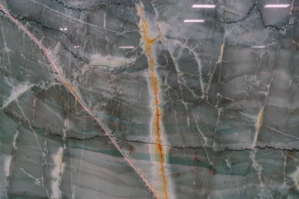 Gray marble wall with white veining and a prominent vertical gold-orange streak.