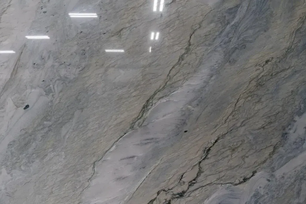 Gray veined marble surface with bright reflections from overhead lights